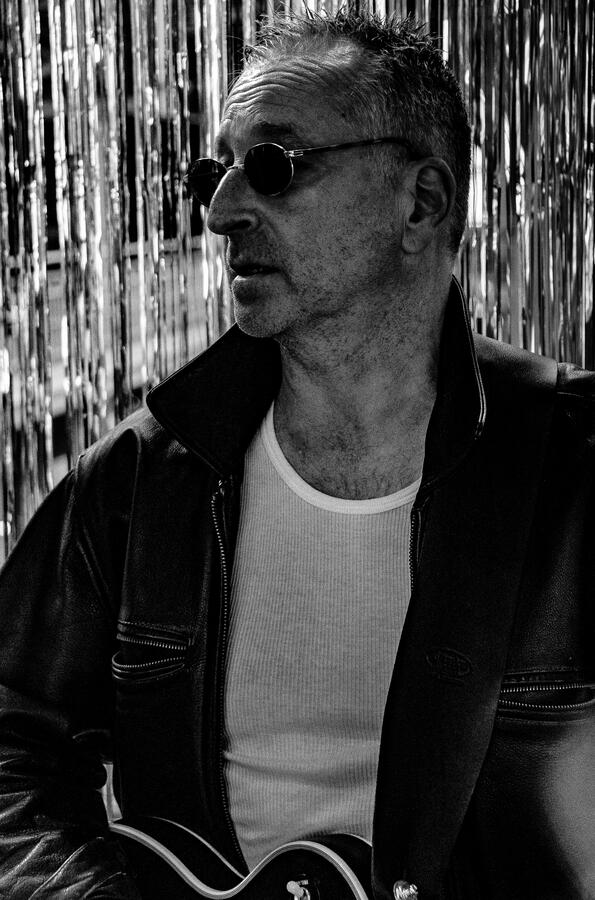 Black-and-white portrait of an independent rock musician with guitar.