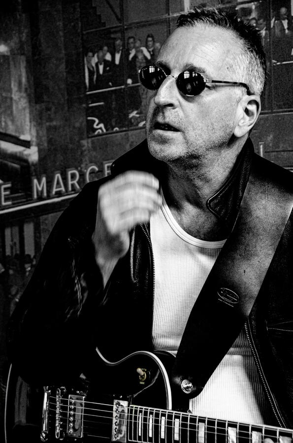 Rock artist portrait in leather jacket, black-and-white.