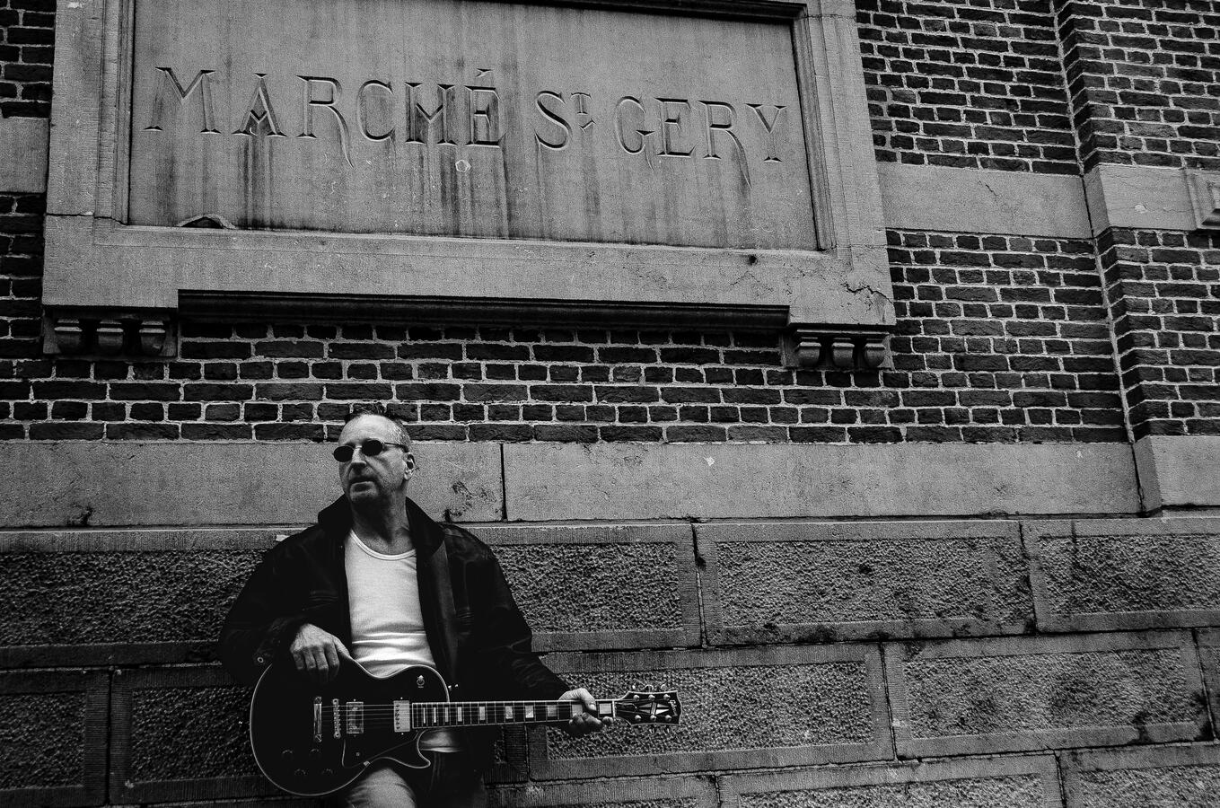 Black-and-white portrait of an independent rock musician with guitar.