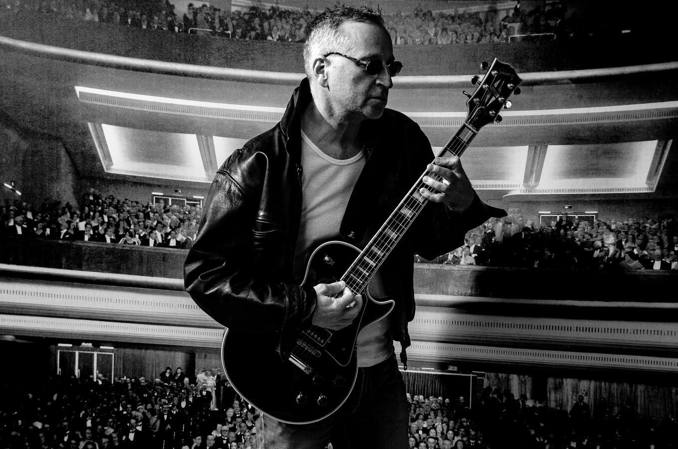 Candid black-and-white music portrait, guitarist in performance pose.