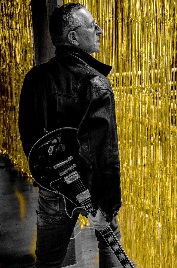 Rock artist portrait in leather jacket, black-and-white.