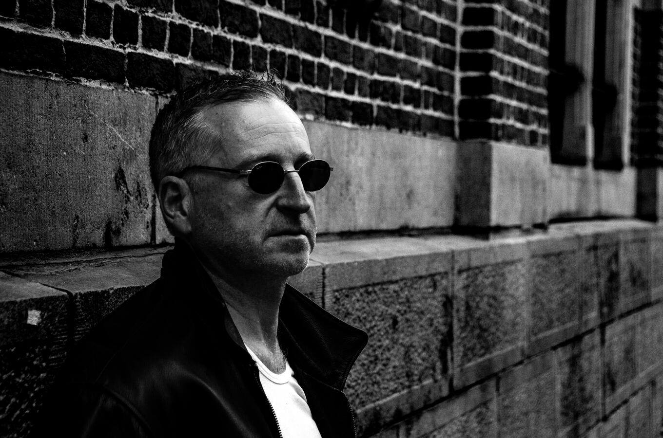 Rock artist portrait in leather jacket, black-and-white.